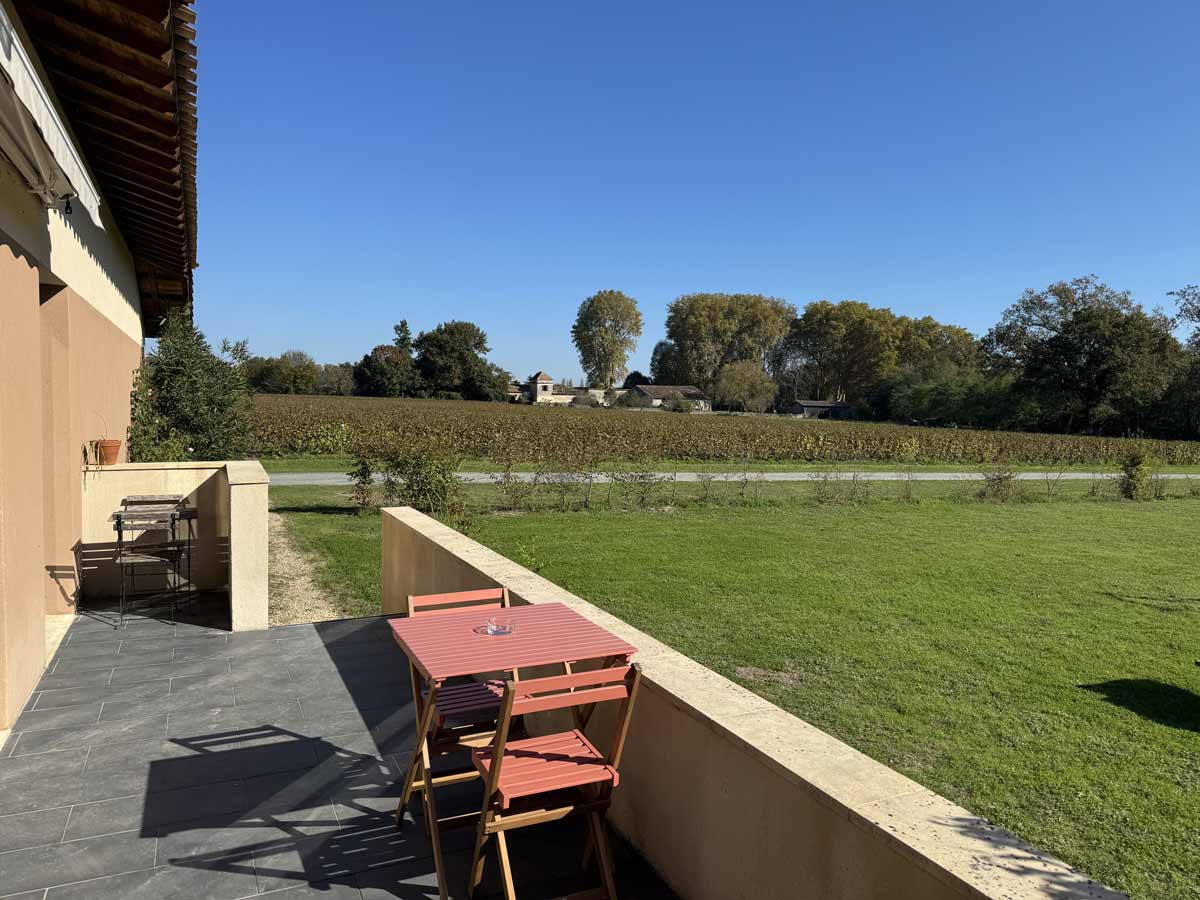 Terrasse du Gîte avec table de jardin et vue sur les vignes et le Château Haut-L 'Artigue